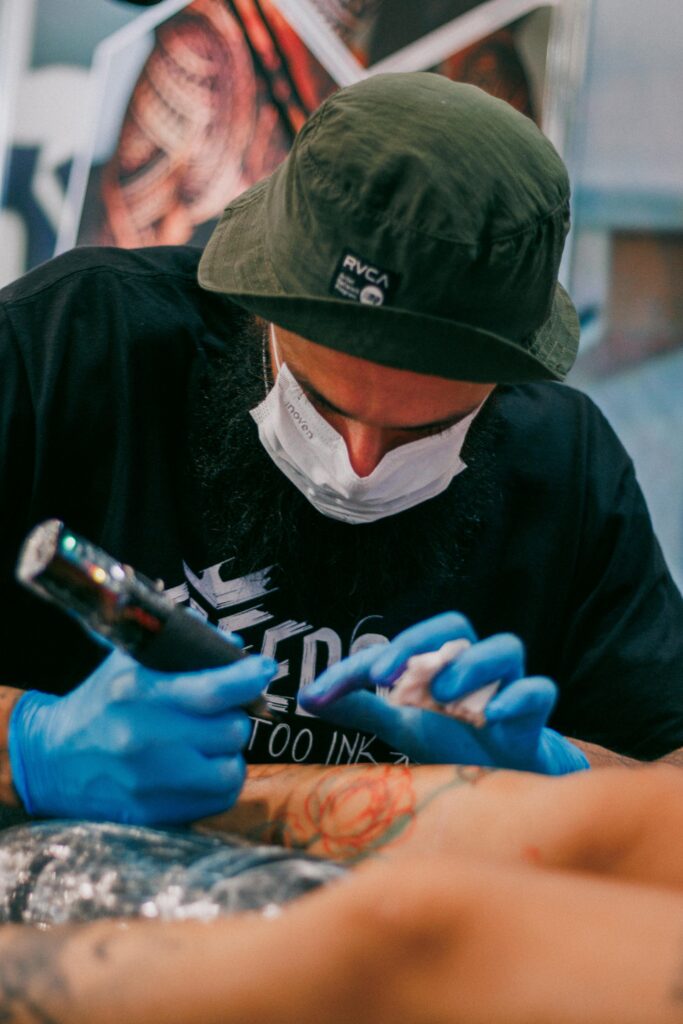 A tattoo artist focused on inking a client's arm with precision and care.